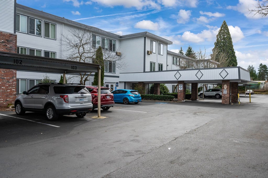 a parking lot with cars in front of a hotel